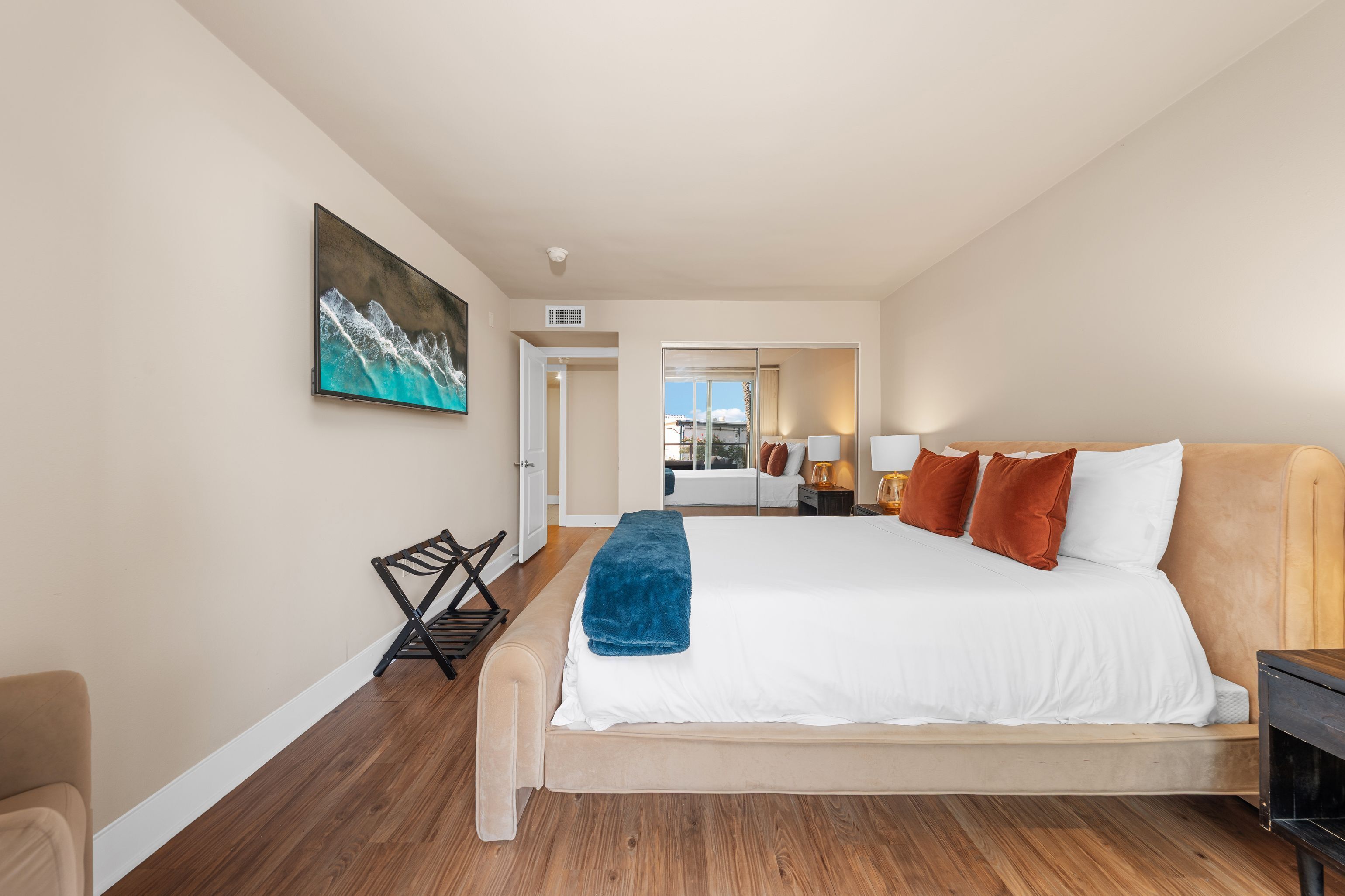 Una habitación de hotel moderna con una cama grande, un área de descanso y vistas a la ciudad.