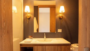 A bathroom with a wooden vanity, a sink, and two wall-mounted lights. - Elegant 3 bedroom apartment in quiet and central area 201 (Medellín)