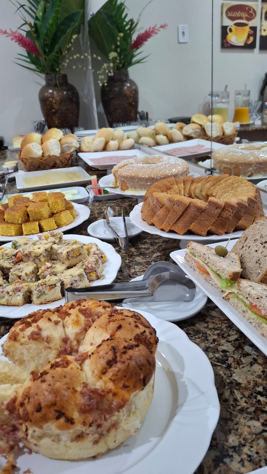 Un bufé con diversos platos, incluyendo pan, sándwiches y una tarta grande.