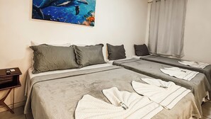 A hotel room with two beds, a painting of a dolphin, and a window with curtains. - Pousada da Orla  (Itacaré)