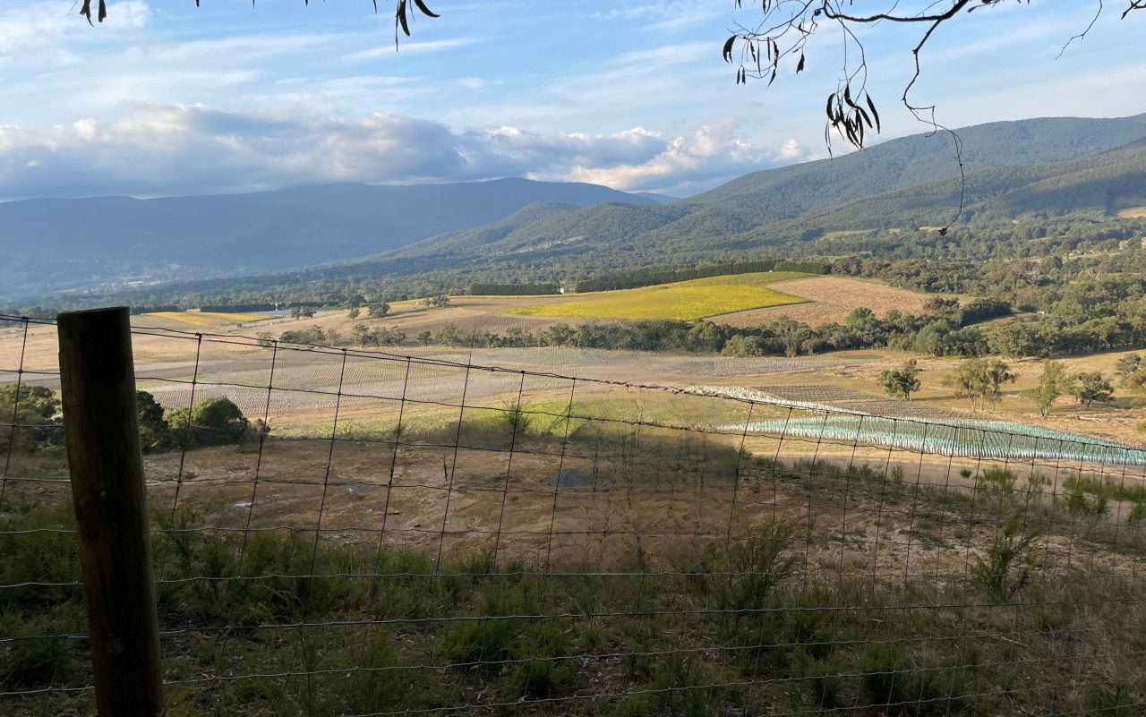 Un espacio al aire libre cercado con vistas a un paisaje montañoso y montañas distantes.