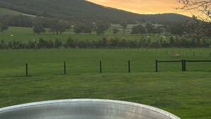 A hot tub in a grassy field with a fence and trees in the background. - Vista 2 drop the bags and look at the view (Yarra Junction)