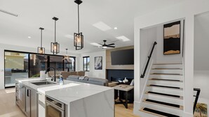 A modern kitchen with a large island, built-in appliances, and pendant lighting. - Brand New w/ Luxury Amenities | AC | Fire Pit | Walk to Beach, Bay, Shops, Eateries (San Diego)