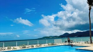 Cielo azul despejado con piscina y vista al océano.