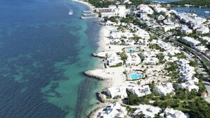 An aerial view of a coastal resort with beachfront villas, a swimming pool, and a marina. - Sea Breeze - NBBC - 2 bedrooms beachfront (Marigot)
