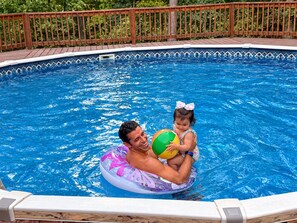 En swimmingpool med ett trädäck och ett säkerhetsräcke.
