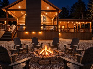 A log cabin with a fire pit and outdoor seating.