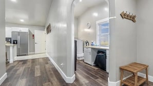Eine geräumige Küche mit weißen Schränken, einem eingebauten Kühlschrank und einem Holztisch.