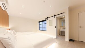 A modern bedroom with a large bed, a sliding door to a bathroom, and a view of the outside. - Gwangju W Lounge Hotel (Gwangju)