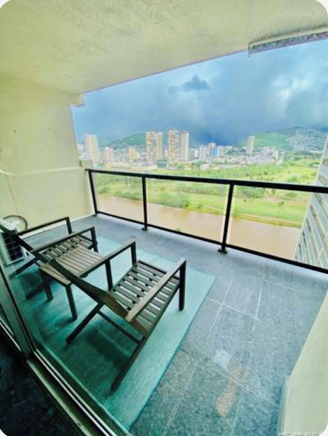 A balcony with a view of a cityscape and a river.