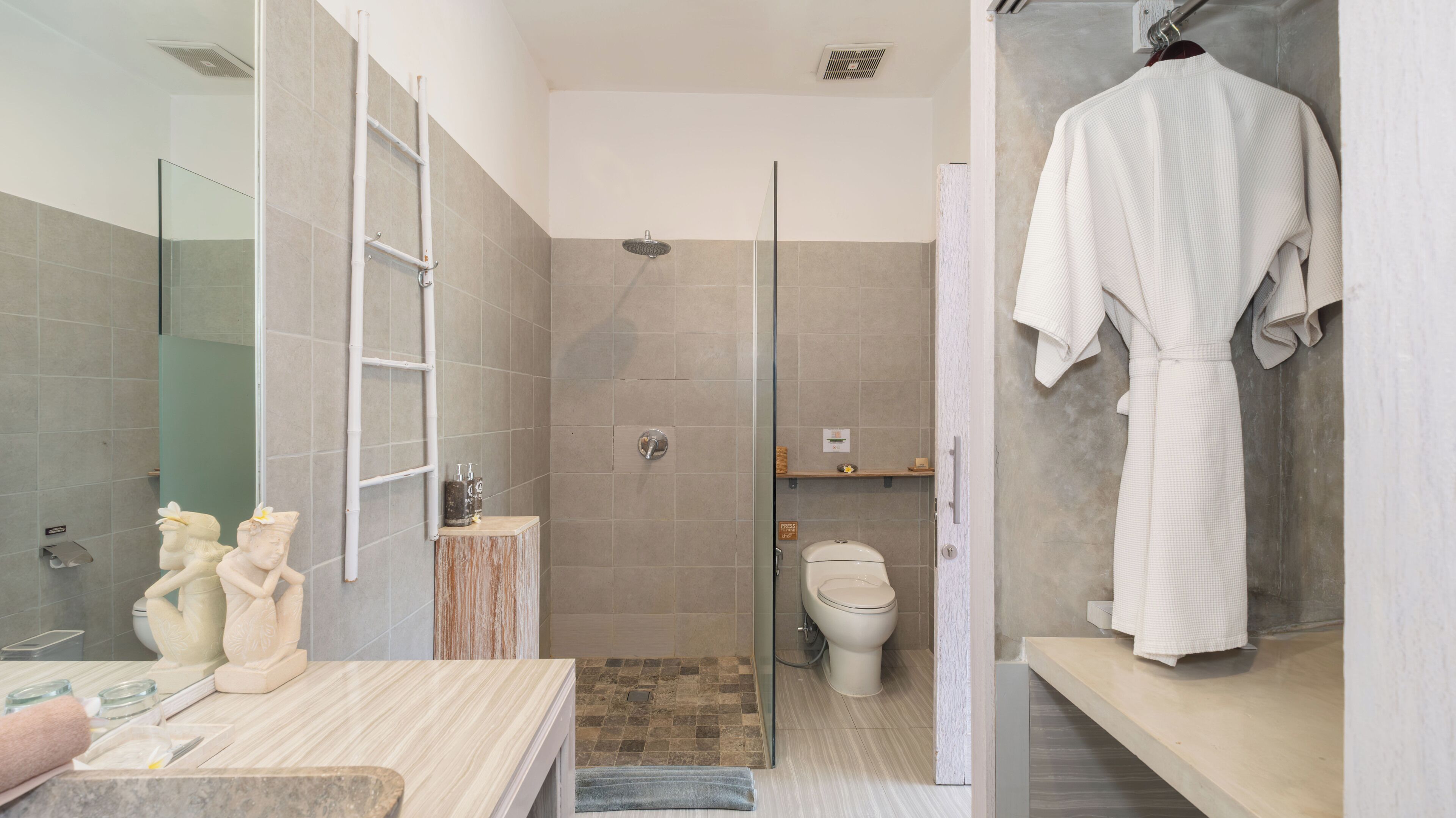 A modern bathroom with a glass shower enclosure, a toilet, and a vanity with a mirror.