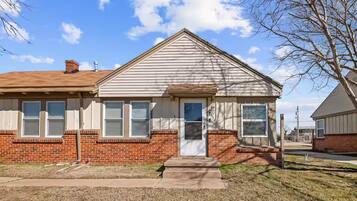 A single-story house with a brick foundation and a gabled roof.