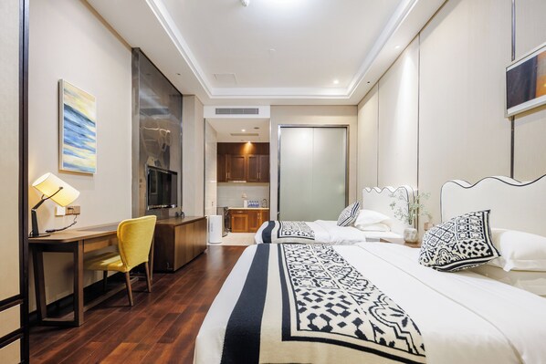 A hotel room with a bed, a desk, a chair, a TV, and a bathroom.