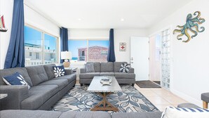 A living room with two grey sofas, a coffee table, and a patterned rug.