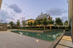 A swimming pool with a traditional building in the background.