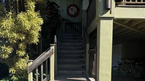 Eine Holztretreppe führt zu einem Gebäude, an dem ein Schild mit der Aufschrift 'LOHA' befestigt ist.