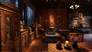 A traditional room with intricate wooden furniture, a stone wall, and a decorative altar with candles. - Sangzhu Kangzhu Luxury Residence (Deqin)