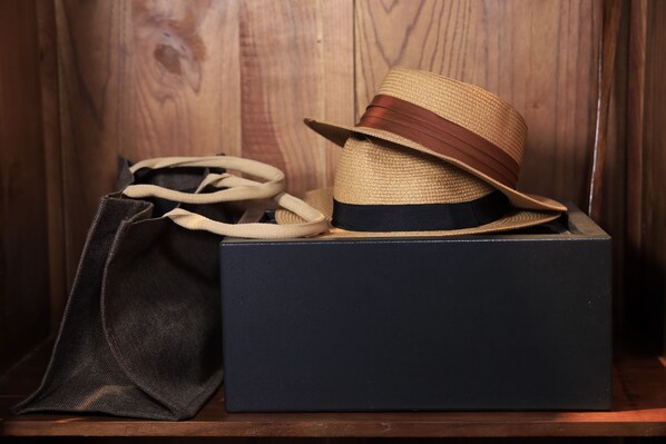 A straw hat with a brown band on a dark blue box.