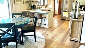 A modern kitchen with a central island, bar stools, and a dining table with chairs. - Sunlit Maple Inn-Rest Awaits You (Hutchinson)