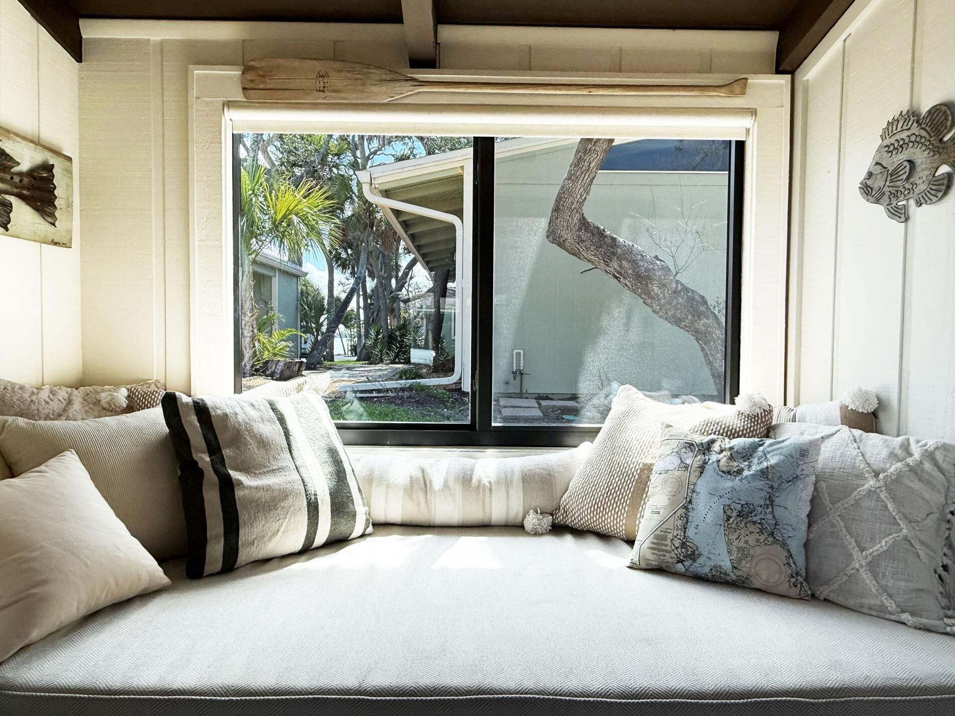 A cozy seating area with a view of a garden and a building.