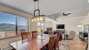 A spacious living area with a large wooden dining table, comfortable seating, a fireplace, and a television. - Stunning Vista at Alpine Buzz (Frisco)
