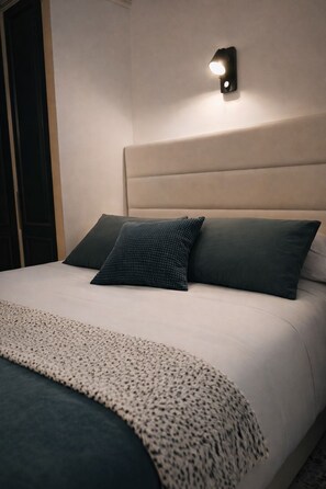 A bed with a headboard, two pillows, and a blanket.