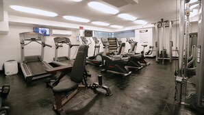 A gym with treadmills, elliptical machines, and weightlifting equipment.