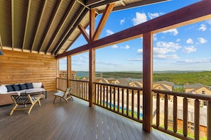 A wooden deck with a view of a lake and buildings.