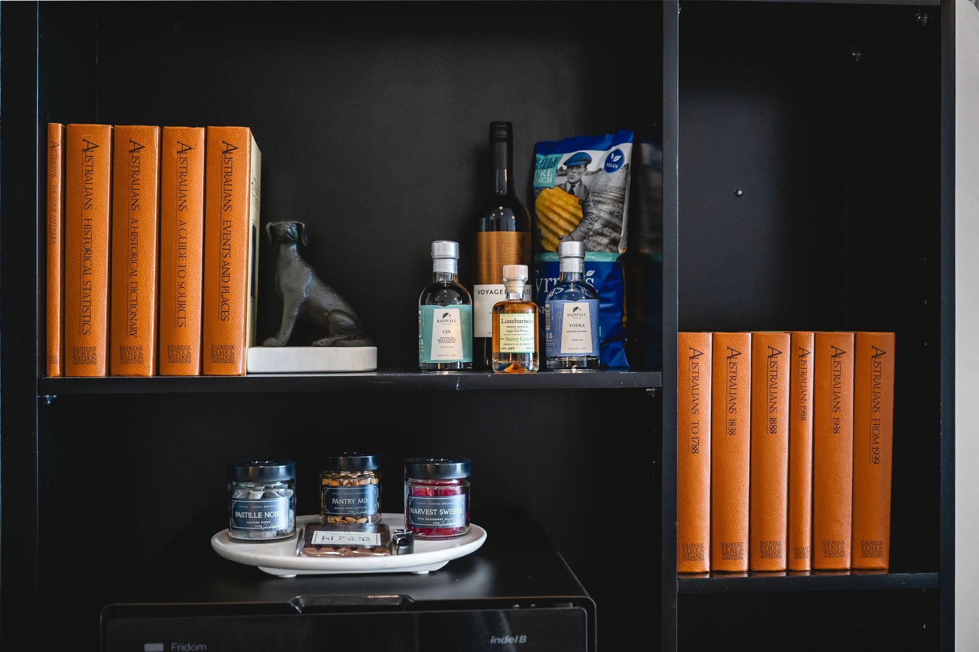 Una estantería con libros, botellas y frascos.
