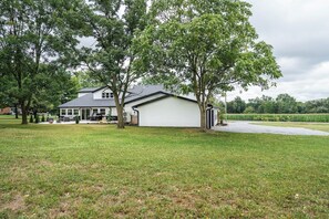 A single-story house with a garage, surrounded by a grassy yard and trees. - Large Group Retreat w/ Indoor Pickleball (Dalton)