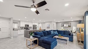 A spacious living room with a dark blue sectional sofa, a coffee table, and a small side table. - Old Town-6 BD + Heated Pool + Hot Tub + Game Room (Scottsdale)
