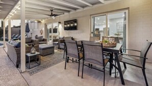 A spacious living area with a dining table, chairs, and a sofa set. - Old Town-6 BD + Heated Pool + Hot Tub + Game Room (Scottsdale)