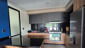 A modern kitchen with a central island, stainless steel appliances, and wooden cabinetry.