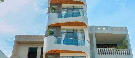 A multi-story building with balconies, a central entrance, and a sign reading 'SERENE SEA'.