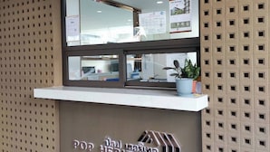 Un comptoir d’accueil offrant une vue dégagée sur l’intérieur, comprenant un comptoir et une plante en pot.