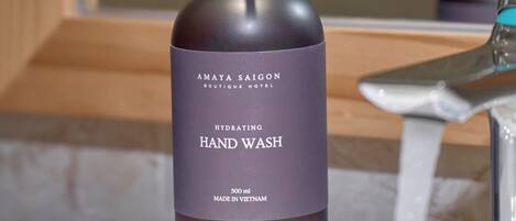 Eine Flasche Amaya Saigon Boutique Hotel Handseife auf einem Badezimmerwaschbecken.