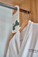 A white garment hanging on a wooden hanger with a tag that includes a cartoon character.
