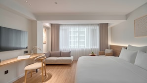 A modern hotel room with a large bed, a desk with a chair, a sofa, and a TV. - Amaya Saigon Boutique Hotel (Ho Chi Minh City)