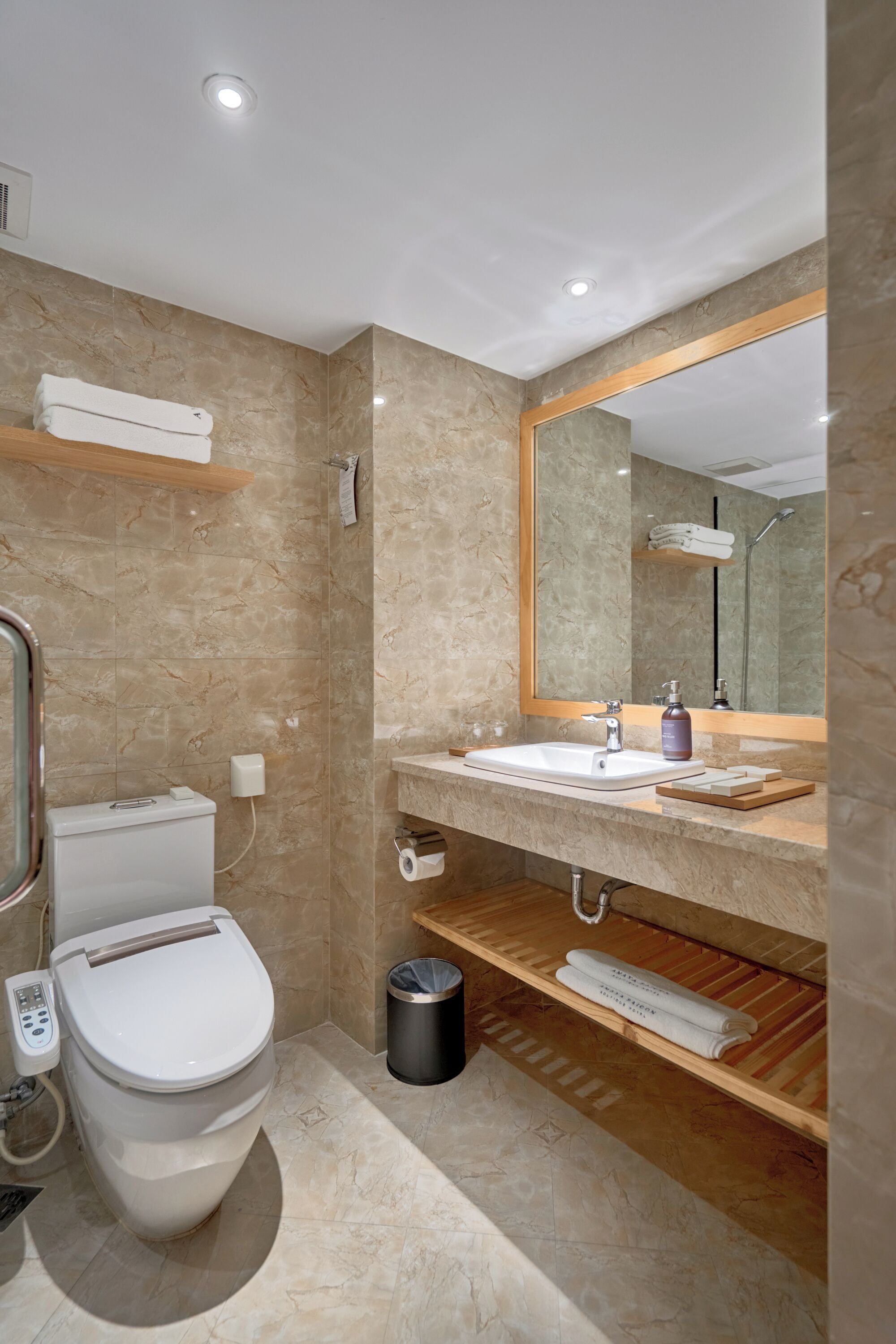 A modern bathroom with a toilet, sink, and mirror.