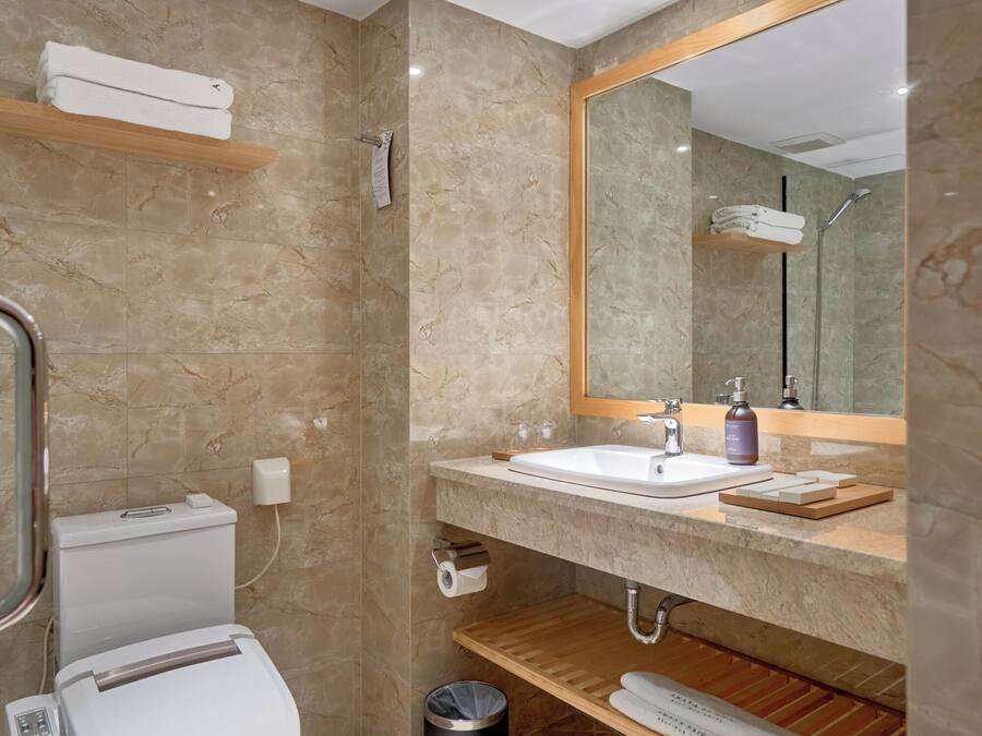 Ein modernes Badezimmer mit Toilette, Waschbecken und Spiegel.