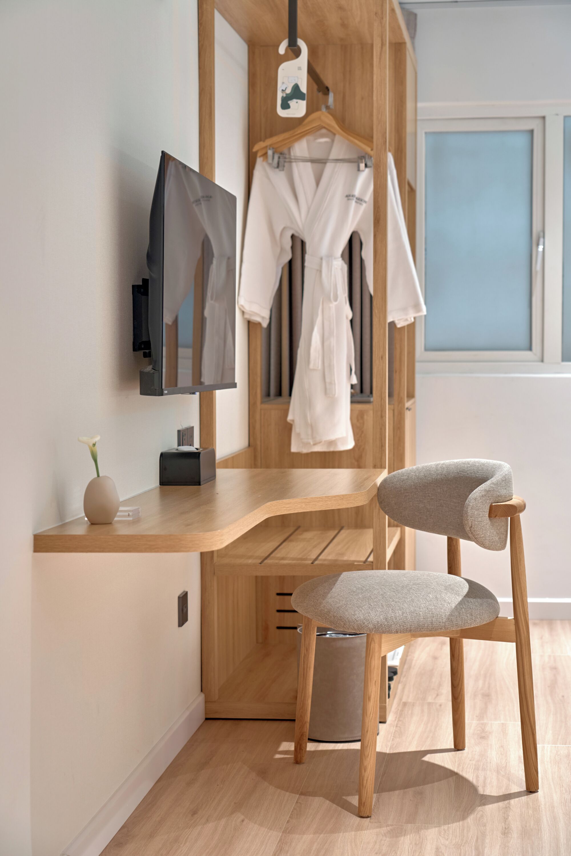 A modern bathroom with a wooden vanity, a mirror, and a towel rack.