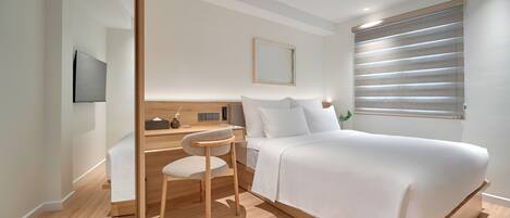 Een moderne slaapkamer met een bed, een bureau en een stoel.