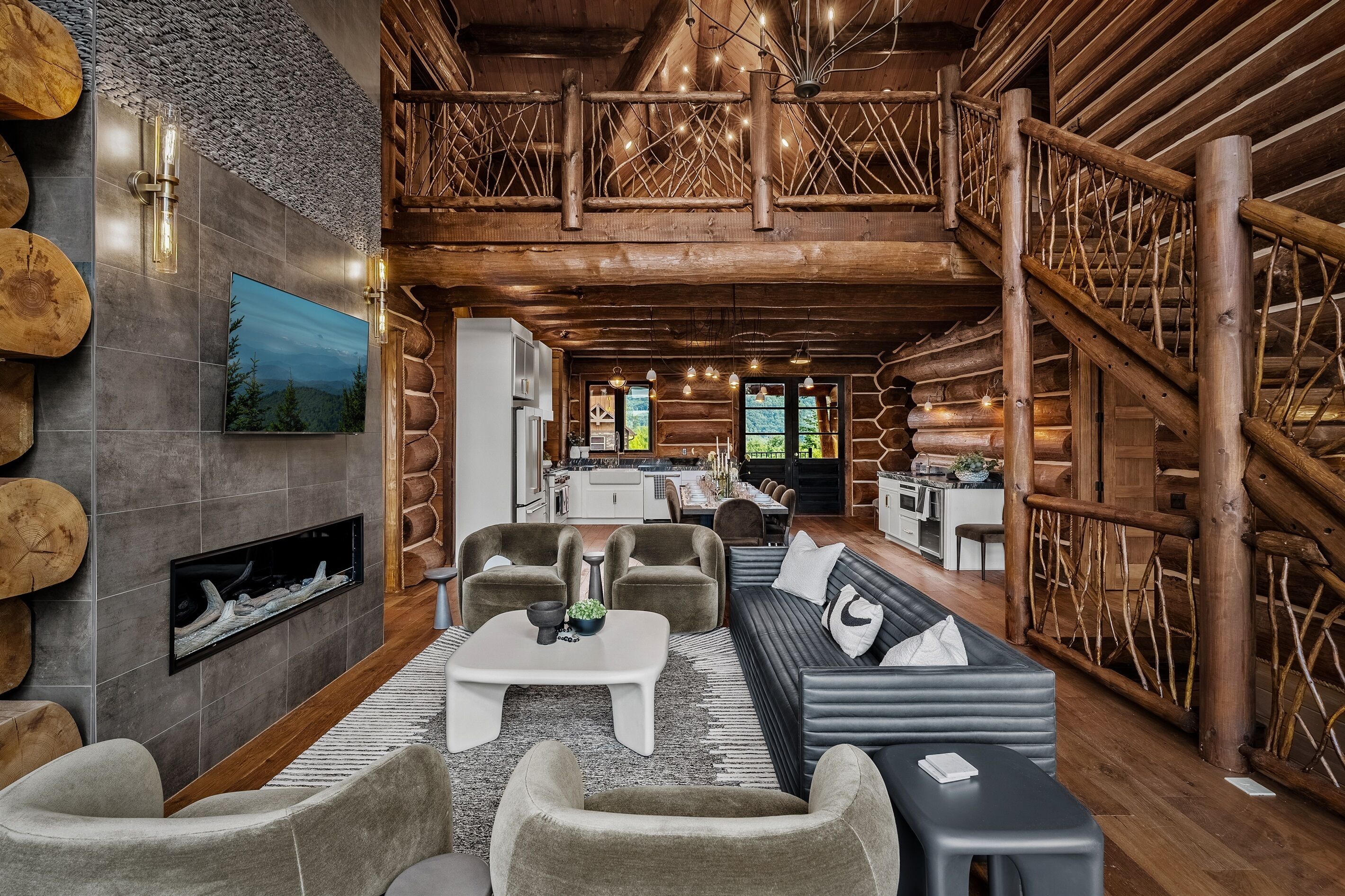 A spacious log cabin interior with a living area, kitchen, and dining space.