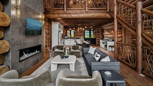 Un intérieur spacieux de chalet en bois, comprenant un salon, une cuisine et un coin repas.