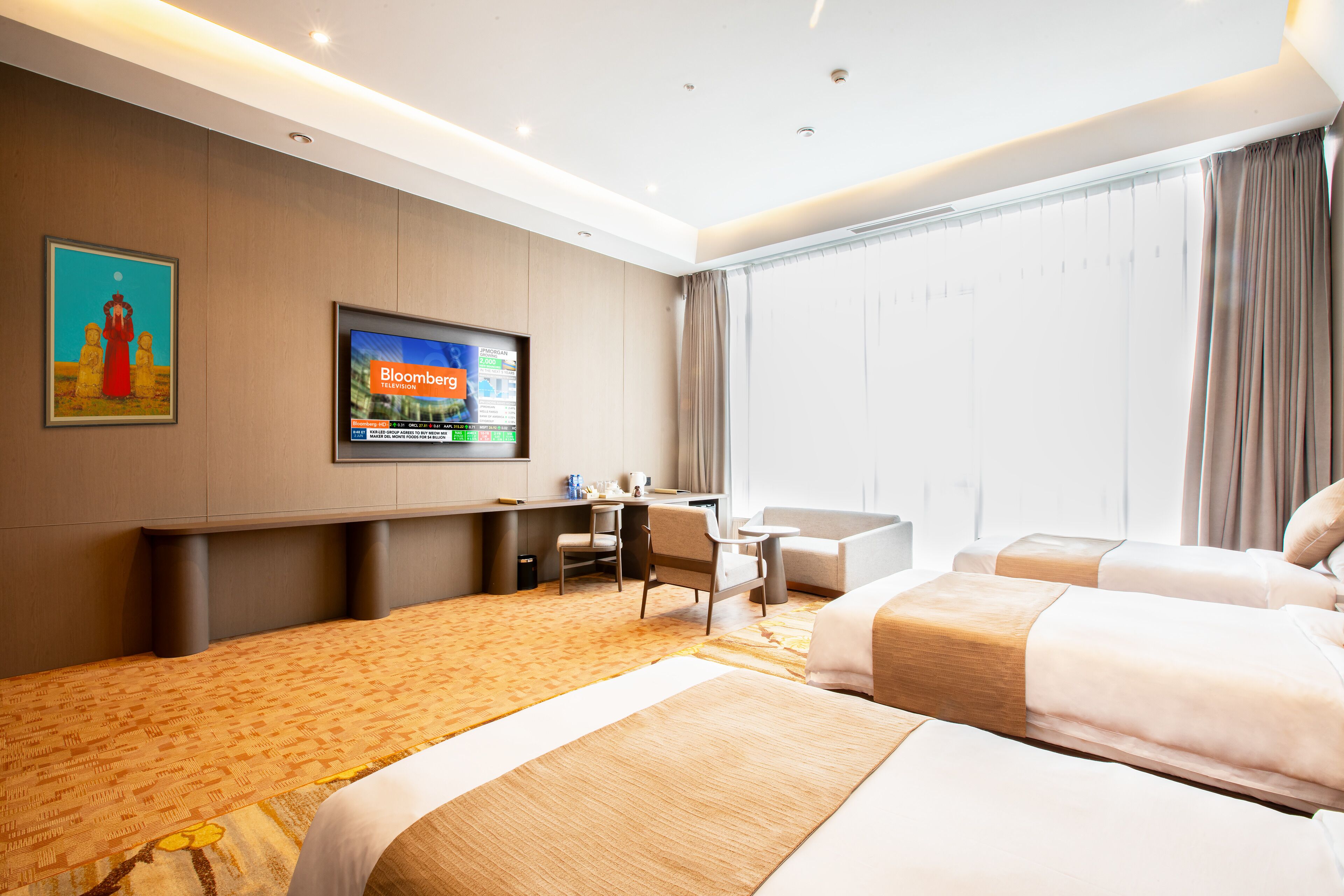 Habitación de hotel con dos camas, un escritorio, una silla, un televisor y un ventanal con cortinas.