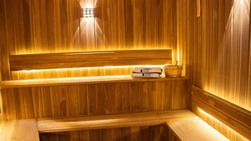 Una sauna de madera con un banco, un estante con una toalla y un perchero.