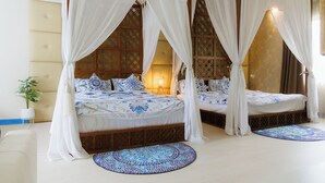 A four-poster canopy bed with a patterned bedspread, a potted plant, and a decorative rug. - Sheva Om (Pak Kret)