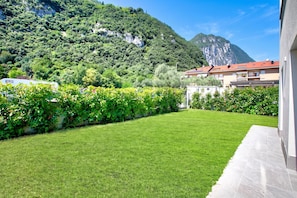 A well-maintained lawn with a clear view of a mountain in the background. - Casa Rudolfo Apartment With Private Garden (Riva del Garda)