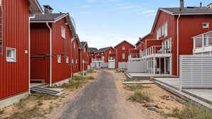 A row of red buildings with a gravel path leading through them.