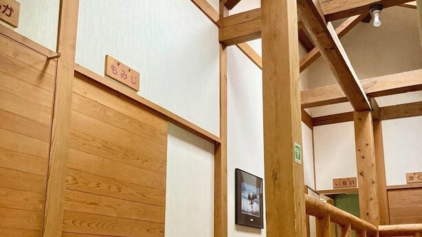 A wooden interior with a skylight, wooden beams, and a framed picture on the wall. - INN KINOSATO (Morotsuka)